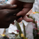 Two people hold hands where former South African leader Nelson Mandela is hospitalized. (Filippo Monteforte/AFP/Getty Images)